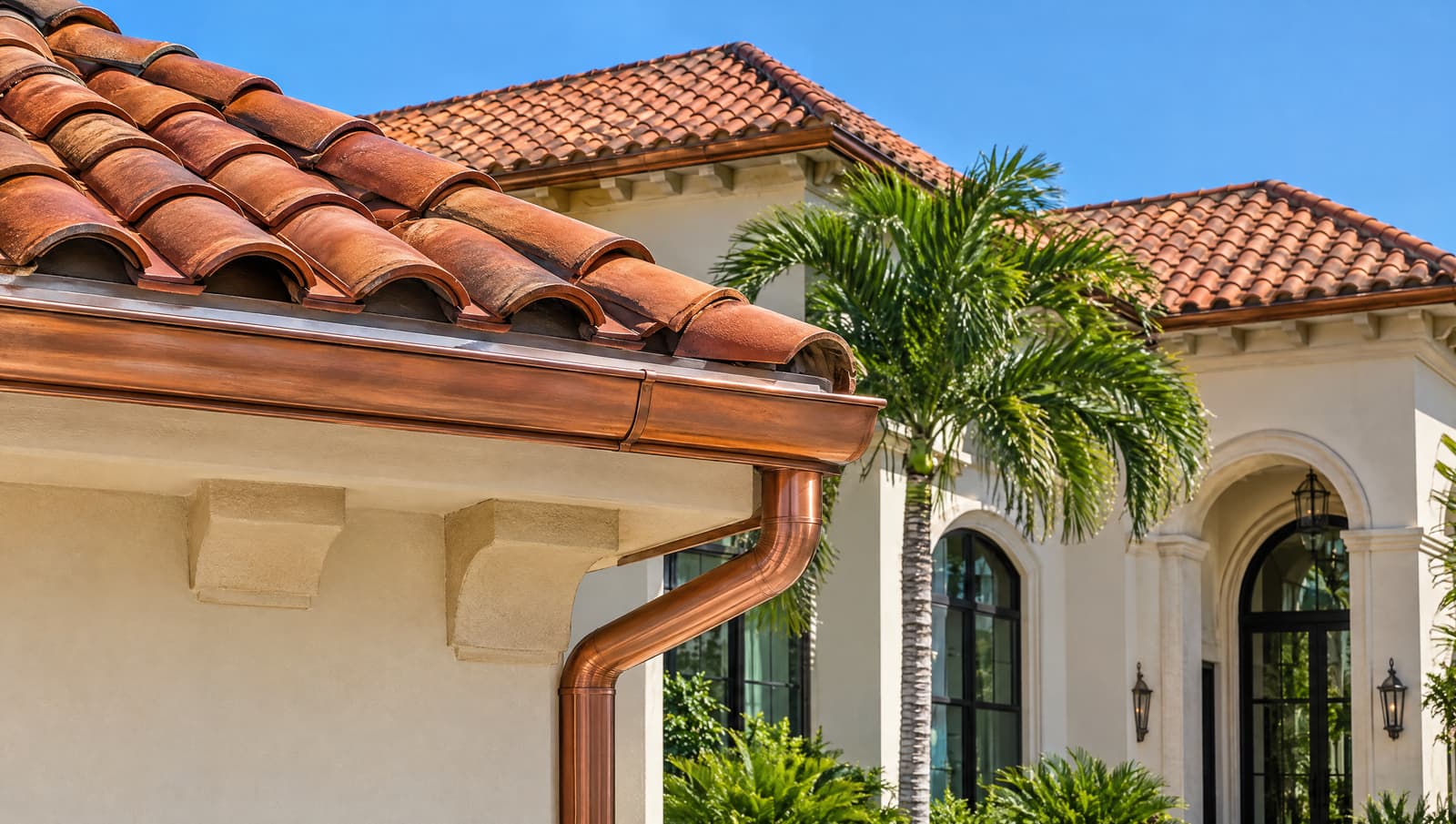Terracotta tile roof and gutter under a clear sky